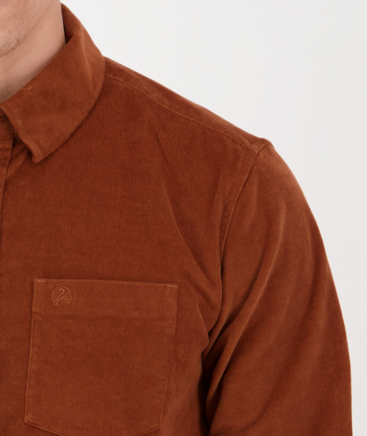 Close-up of a person wearing the Swanndri Ranfurly Corduroy Shirt with a tailored fit and collar. It features a chest pocket against a light background, showing only part of their neck and shoulder.