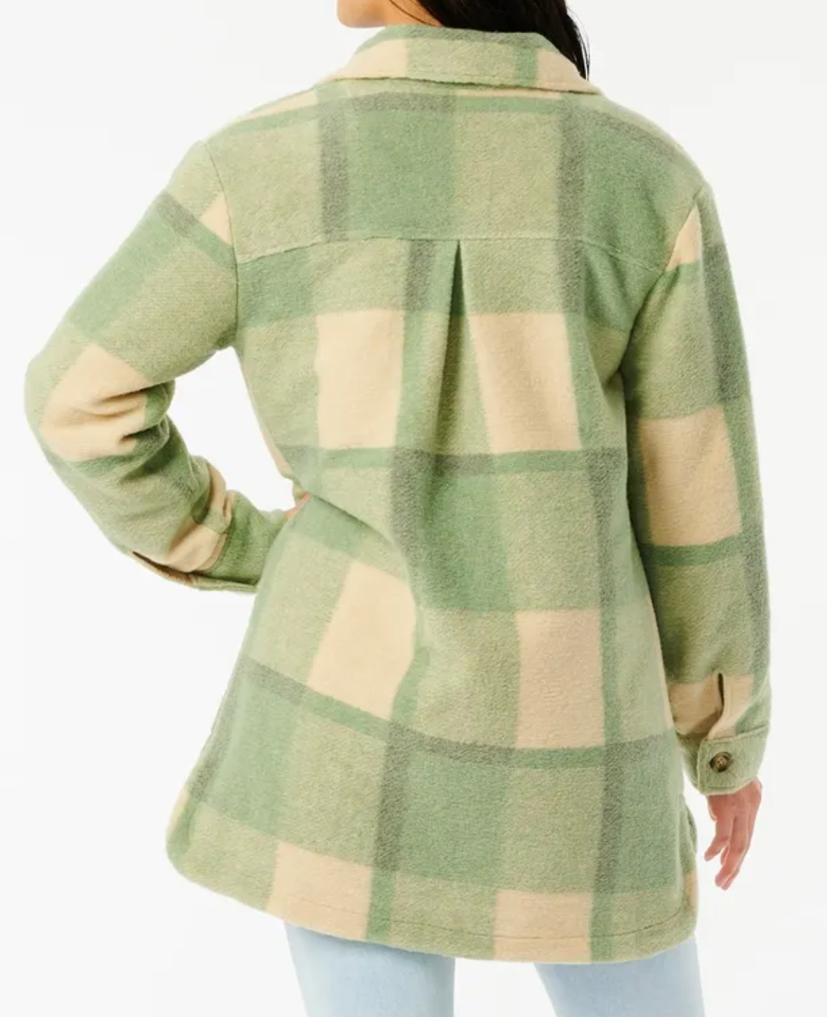 A person in a Rip Curl Maniciana Jacket, featuring a green and beige plaid design with long sleeves, is seen from the back. They're also wearing light blue jeans against a plain white background.