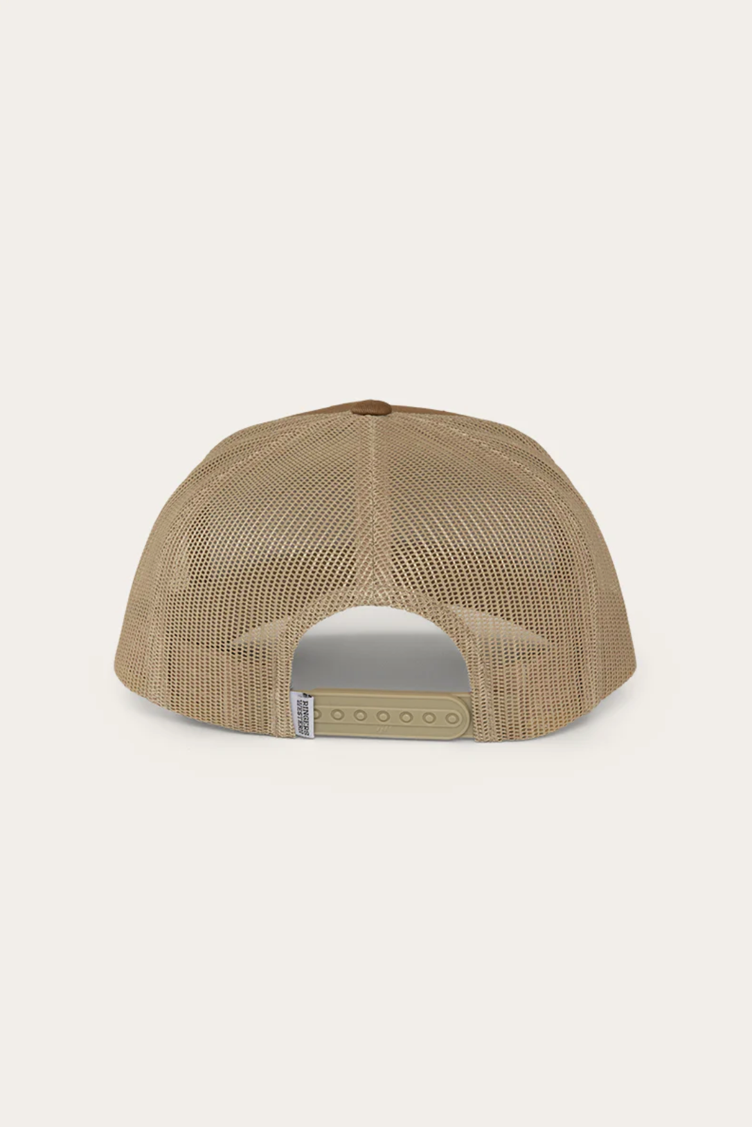 The Ringers Western Jaxton Trucker Cap is a tan mesh baseball cap featuring a brown top button, adjustable tan strap closure with multiple sizing holes, and made from Cotton Twill.