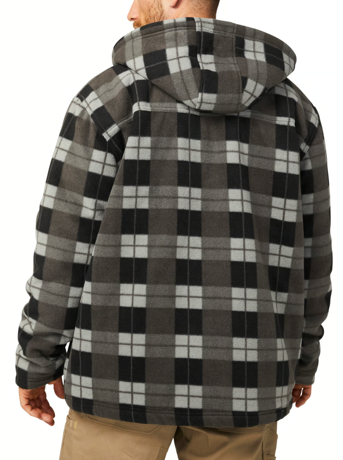 A man is seen from the back wearing a CAT Active Work Jacket in a black, gray, and white plaid pattern featuring adjustable cuffs. He pairs it with light brown pants indoors.