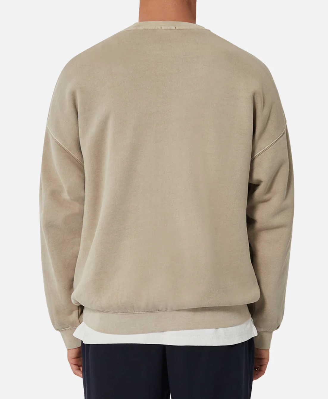 A person is seen from behind, wearing the Industrie The Del Sur Sweat in an oversized beige fit, layered with a white shirt peeking through. Dark pants complete the look against a plain white backdrop.
