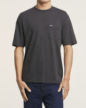 A person is wearing a Wrangler Classic Pocket Tee made from 100% cotton with a chest pocket, paired with dark blue jeans. They stand against a plain white background, arms relaxed at their sides.