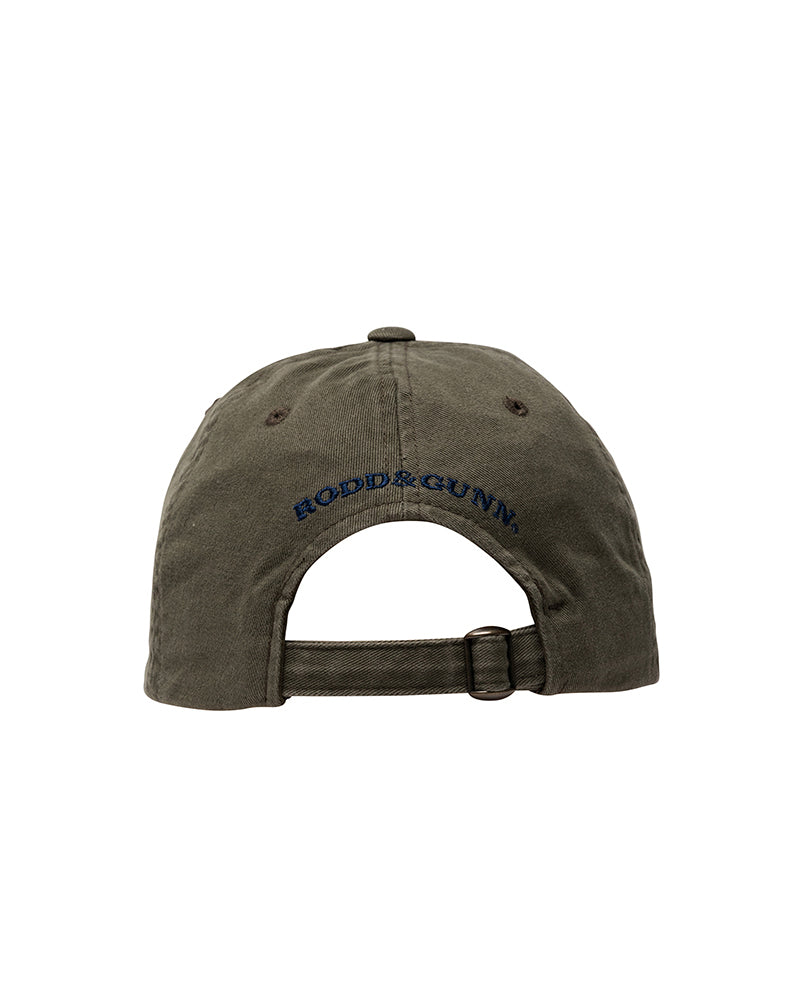 The Rodd & Gunn Signature Cap is an olive green baseball cap made from cotton twill, featuring an adjustable strap. "Rodd & Gunn" is embroidered in navy blue text above the rear opening.