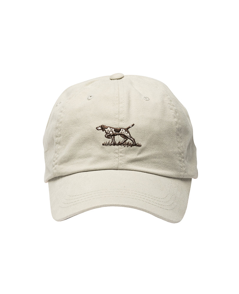 The Rodd & Gunn Signature Cap is a beige baseball cap made from durable cotton twill, featuring an embroidered design of a hunting dog in a pointing stance on the front. It boasts a classic curved bill and an adjustable strap at the back.