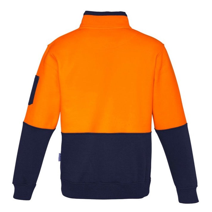 The Syzmik Hi Vis Half Zip Pullover is a high-visibility safety sweatshirt with long sleeves, featuring a bright orange upper section and dark navy blue lower section. This 100% Polyester pullover also includes a navy collar, waistband, and cuffs, with an additional dark patch on one sleeve for added detail.