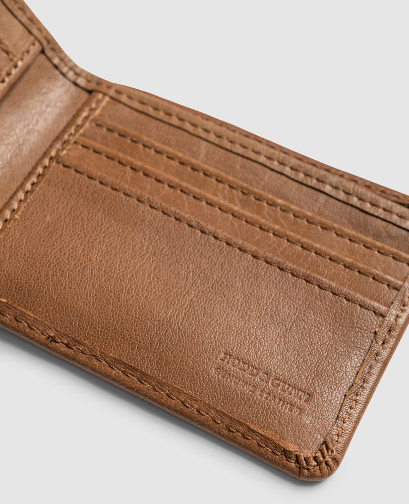 Close-up of an open Rodd & Gunn Victoria Flats Road Wallet made from buffalo leather, showcasing intricate stitching and multiple card slots. The "Leather & Cloth" logo is embossed in the corner, set against a plain, light-colored background.