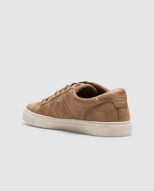 The Rodd & Gunn Endeavour Spirit Sneaker showcases brown nubuck leather, a white sole, and minimalist stitching from a back-left view. This lace-up footwear stands out elegantly against a light gray background, blending style with subtle sophistication.