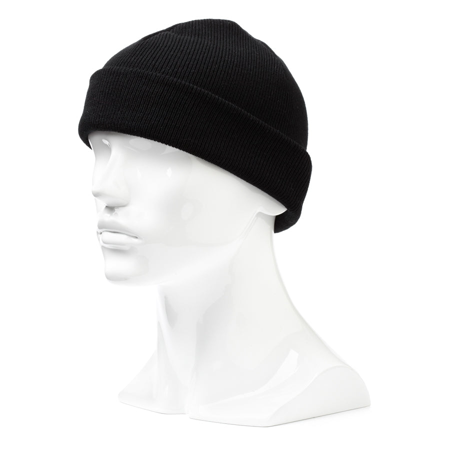 A white mannequin head wearing the Rainbird Watchman Beanie in plain black acrylic double knit. The mannequin's smooth, featureless face pairs with the comfortable beanie, which features a turn-up cuff at the edge.
