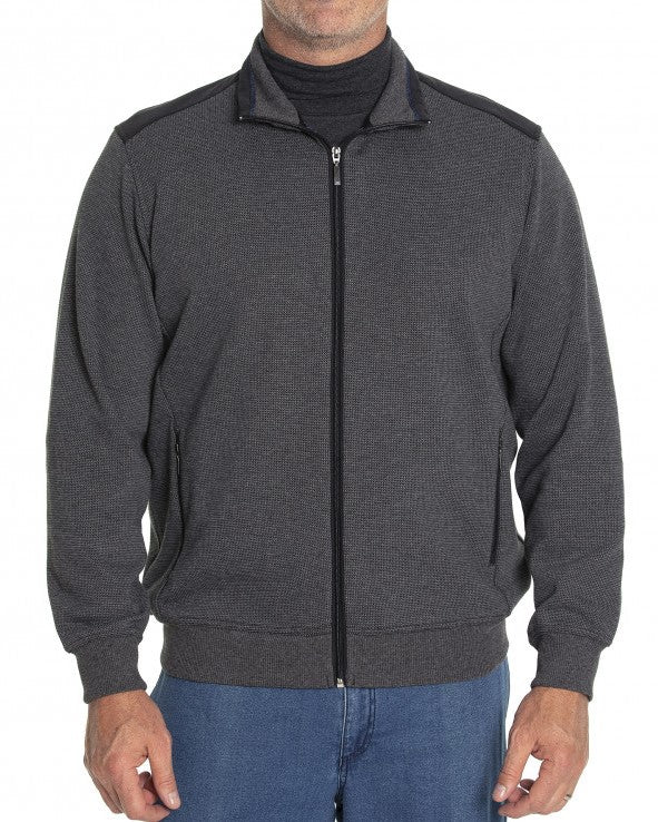A person wearing the Breakaway Ryan Jacket, a stylish dark grey zip-up jacket with a high collar, over a dark shirt, paired with blue jeans. The person is standing against a plain white background.