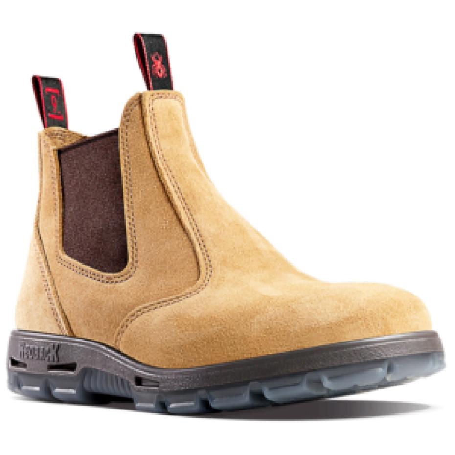 Introducing the Redback USBBA Bobcat Safety Toe, a tan suede Chelsea work boot featuring black elastic side panels and a pull tab with distinctive red branding at the back. Designed for heavy-duty wear, it boasts a durable gray sole and reinforced stitching for added durability and comfort. Handmade in Australia, this boot is built to withstand tough conditions while providing exceptional support.