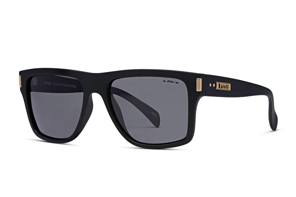 A pair of Liive Casino Polar Sunglasses featuring black rectangular frames and dark-tinted, polarized grey lenses. The wide temples and frame rims are adorned with gold accents, including a small gold and black "Live" logo on the left temple. These UV protection glasses boast a polished finish.