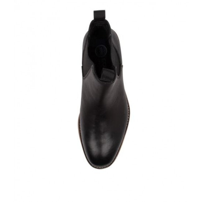 Top view of a single Colorado Brumby Boot in black, featuring a rounded toe, elastic sides, and a pull tab at the back. The leather boot boasts a sleek, polished finish with a visible stitched sole.