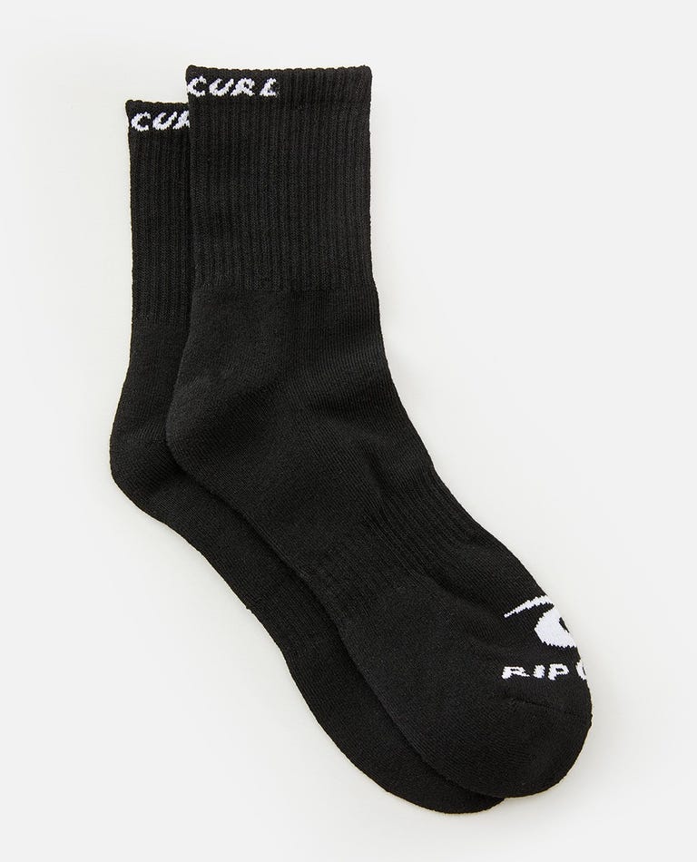 The Rip Curl Corp Crew Sock 5 Pack features pairs of black socks with white branding. The logo and text "RIP CURL" are visible on the top rim and near the toe area of each sock. Designed for men's sizes 9-13, these socks have a ribbed texture at the cuff and a smooth finish below the ankle.
