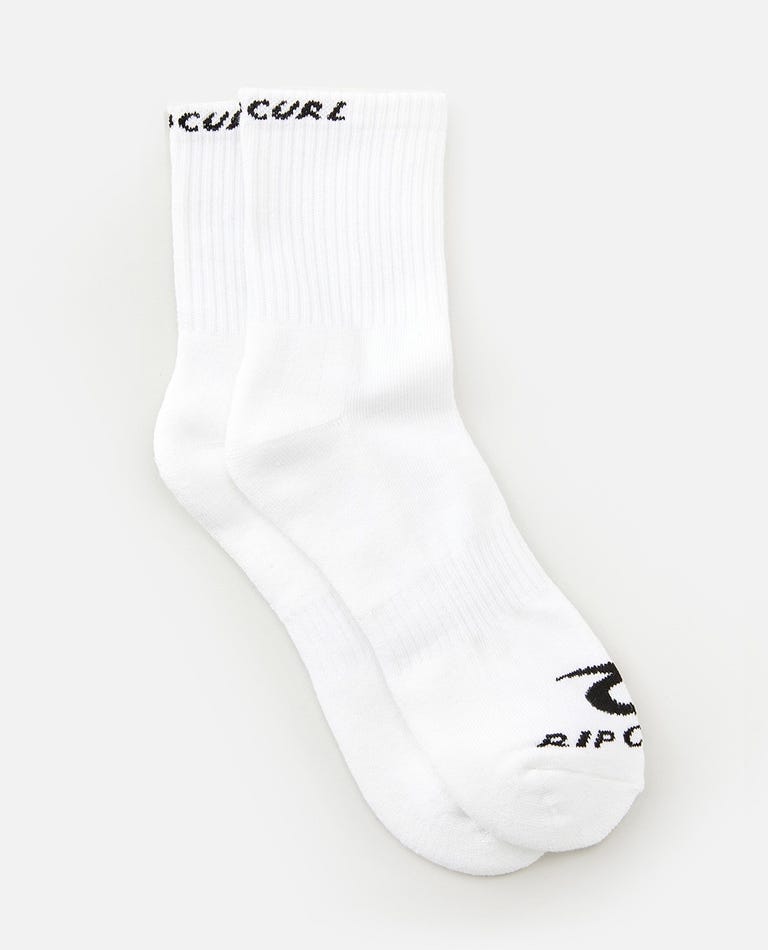 Two white socks from the Rip Curl Corp Crew Sock 5 Pack, size Men's 9-13, are displayed on a plain white background. "Rip Curl" is written in black on the top of the cuff and by the toes of each sock. The socks are placed side by side, slightly overlapping each other.