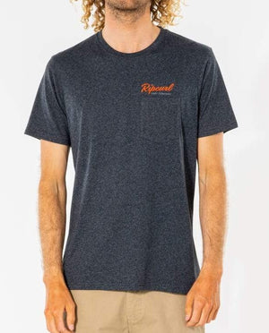 A person stands against a plain background in beige pants and a Rip Curl Solid Too Easy Embroid Tee, featuring orange text on the chest and a dark gray crew neck design.