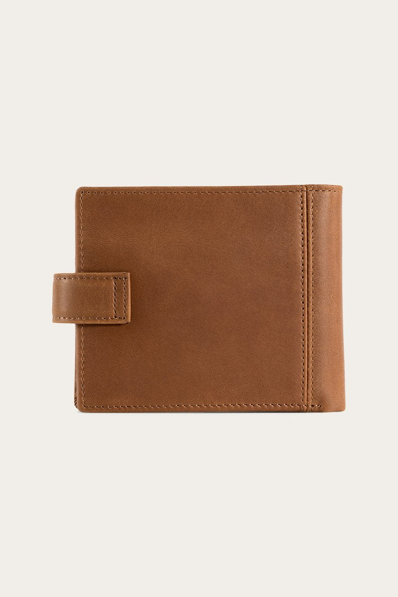 The Ringers Western Cypress Wallet, crafted from genuine leather, features a classic strap closure and is elegantly displayed against a plain light background.