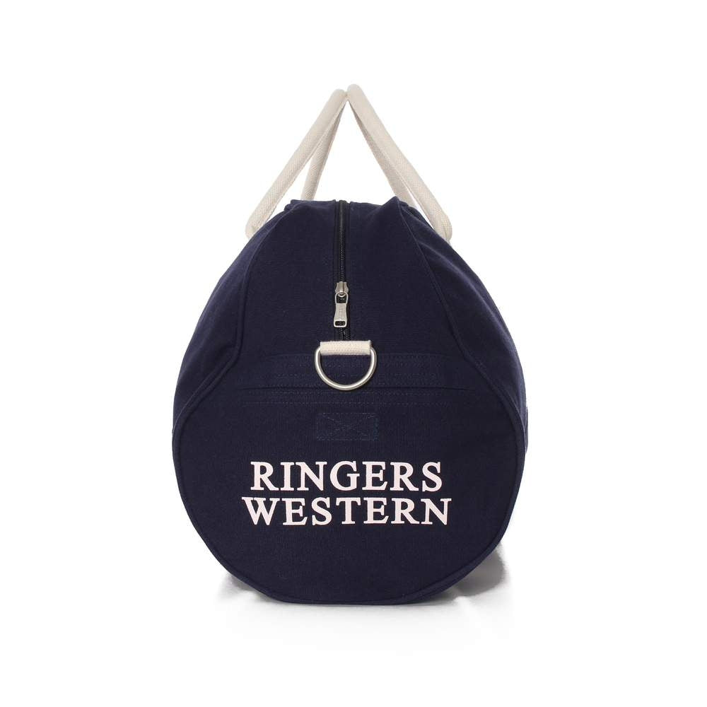 The Ringers Western Gundagai Duffle is a cylindrical, navy blue cotton canvas bag with white handles and a zipper top, featuring "RINGERS WESTERN" printed in white letters on the front.