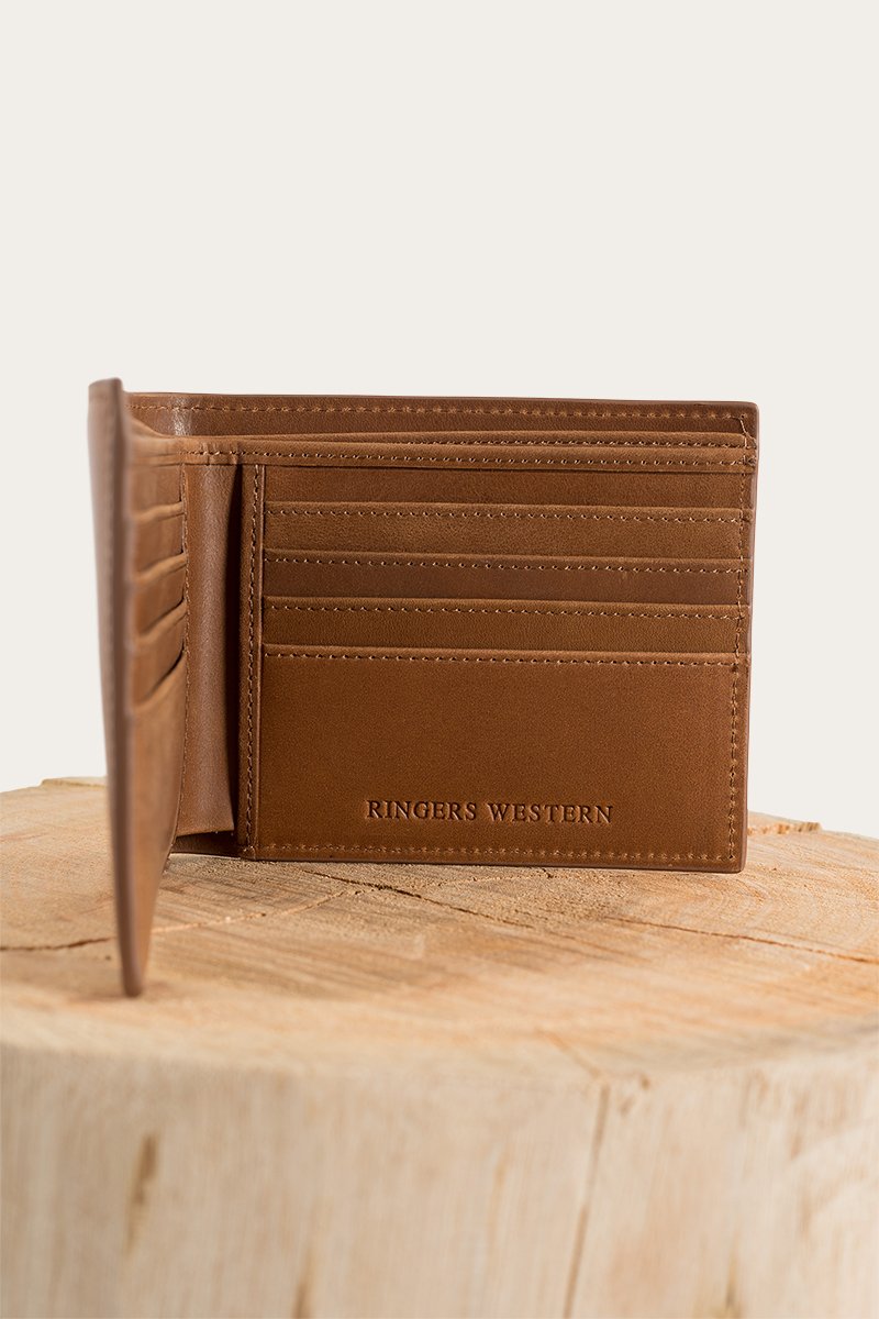 The Ringers Western Duke Wallet is made from genuine leather and includes multiple card slots. It is displayed open on a wooden surface against a plain background.