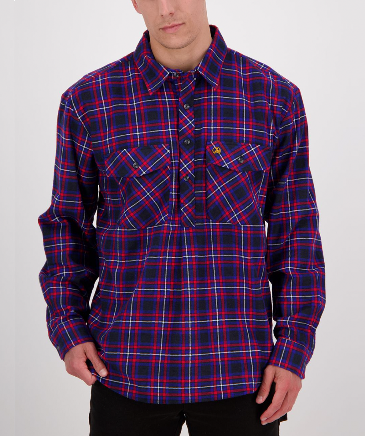 A man models a red, blue, and black checked long-sleeve shirt from the Swanndri Egmont Flannelette Twin Pack against a white backdrop.