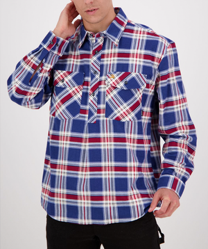 The Swanndri Egmont Flannelette Twin Pack features a cozy blue, red, and white checkered plaid long sleeve shirt with two buttoned chest pockets. A plain white background highlights the casual attire as they rest one hand on their neck.