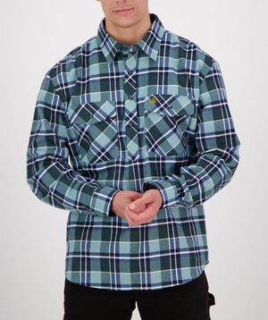 Someone adjusts the brushed cotton cuffs of a blue and green plaid long sleeve Swanndri Egmont Flannelette shirt, featuring buttoned chest pockets with a logo, against a plain background. The person's face is not visible.