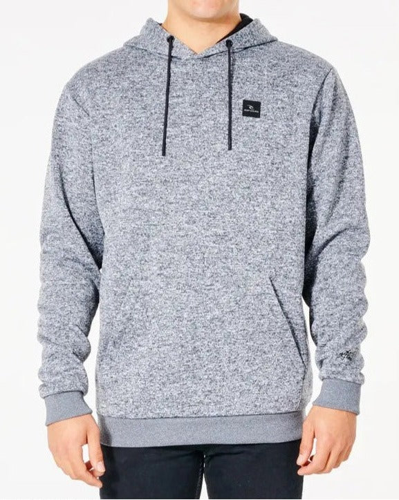 The person is wearing a light gray Rip Curl Anti Series Crescent Hood with black drawstrings and a small black square logo on the chest, featuring a marled texture and ribbed cuffs on the wrists and hem, against a plain background.