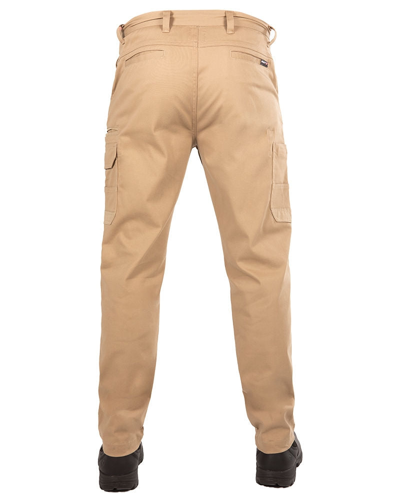 A rear view of a person wearing the UNIT Demolition Stretch Cargo Pant in beige and black shoes. The durable work pant features cargo-style pockets on both legs and belt loops at the waist. The person's legs are slightly apart, and the photo is taken against a white background.