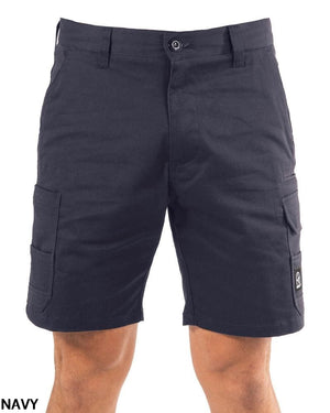 A person wears UNIT Demolition Stretch Cargo Shorts—knee-length, navy, made from durable stretch fabric with buttoned cargo pockets and a small UNIT logo patch on the left pocket. "NAVY" appears in the bottom left corner.