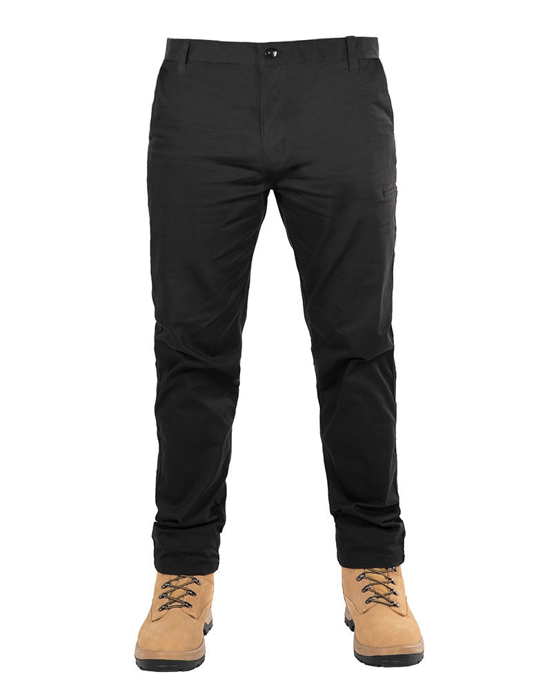 A person wearing the UNIT Ignition Stretch Pant and tan lace-up boots stands in front of a white background. The focus is on the lower body, highlighting the pants and boots.