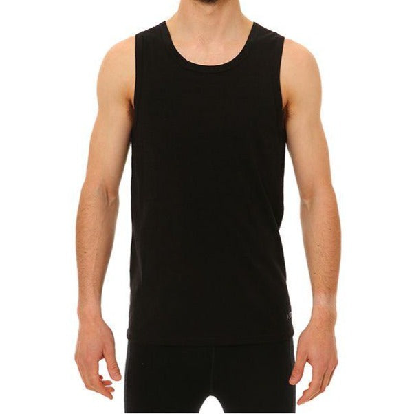 A person wearing the XTM Merino Tank, a black odour-repellent sleeveless top, and black pants stands against a white background, facing the camera with their head not visible in the image.