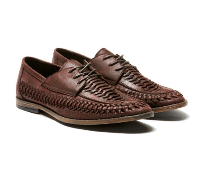 A pair of UNcut Lido Shoes made from woven brown leather, complete with laces. The intricate weave pattern extends across the toe and sides, adding to their elegant design. These comfortable shoes feature low heels and dark soles. Both shoes are positioned side by side, facing slightly to the right.