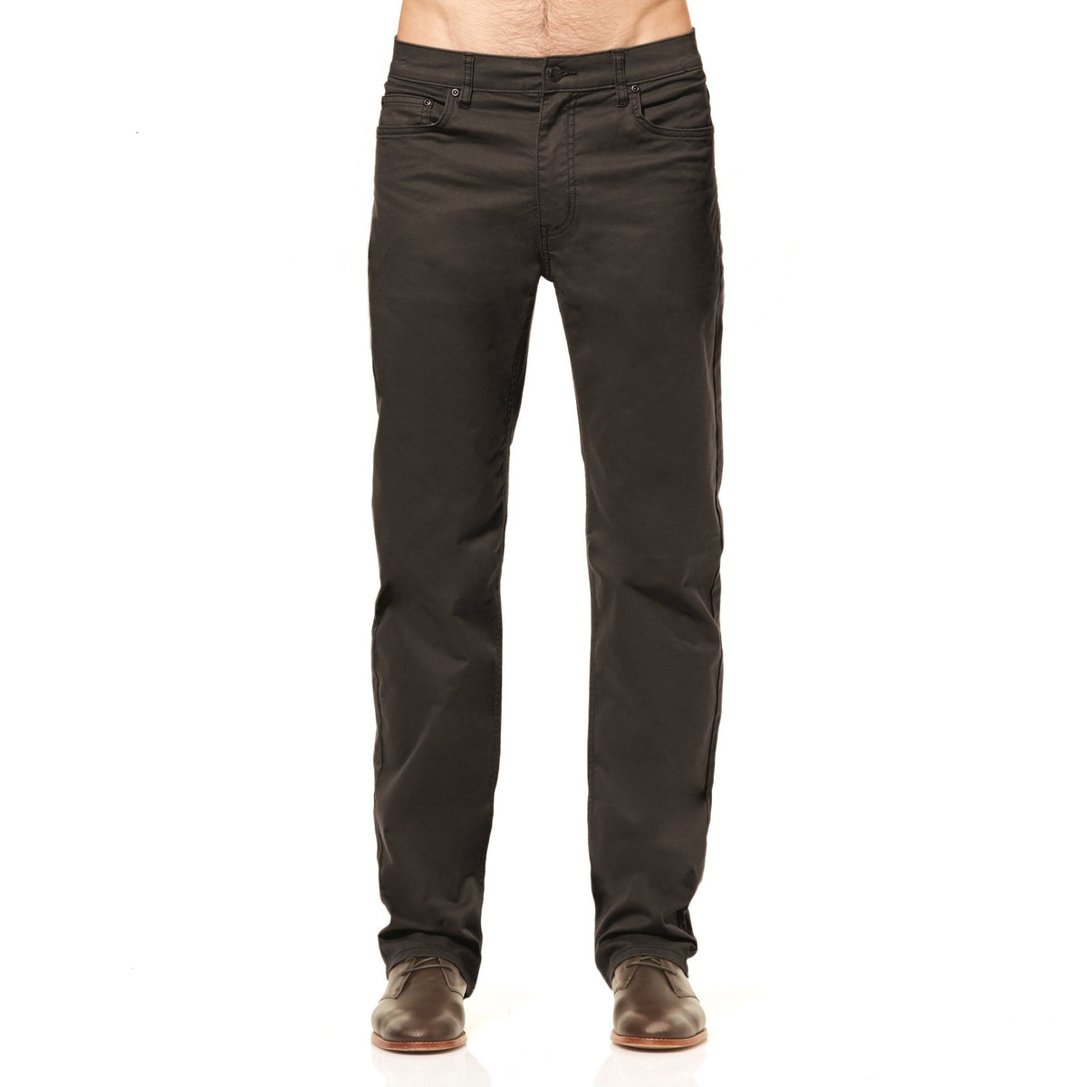 A person wearing Riders Straight Pant Stretch, dark-colored with a cotton elastane blend, and brown shoes stands against a white background. The stylish pants feature a simple design with pockets and a front fly. The upper part of the person is not visible.