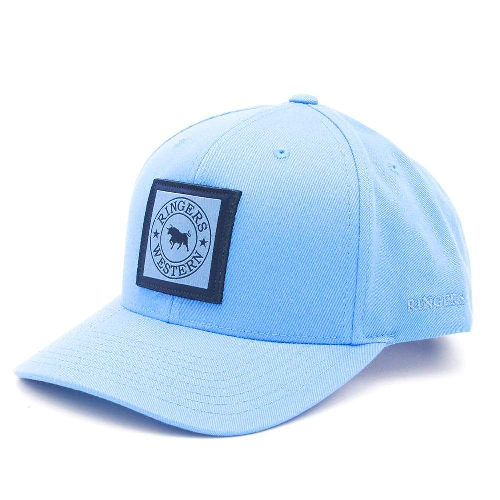 The Ringers Western Twill Baseball Cap is light blue and made of cotton, featuring a curved brim and adjustable back strap. It has a black front patch with a circular bull logo and the words "Ringers Western.