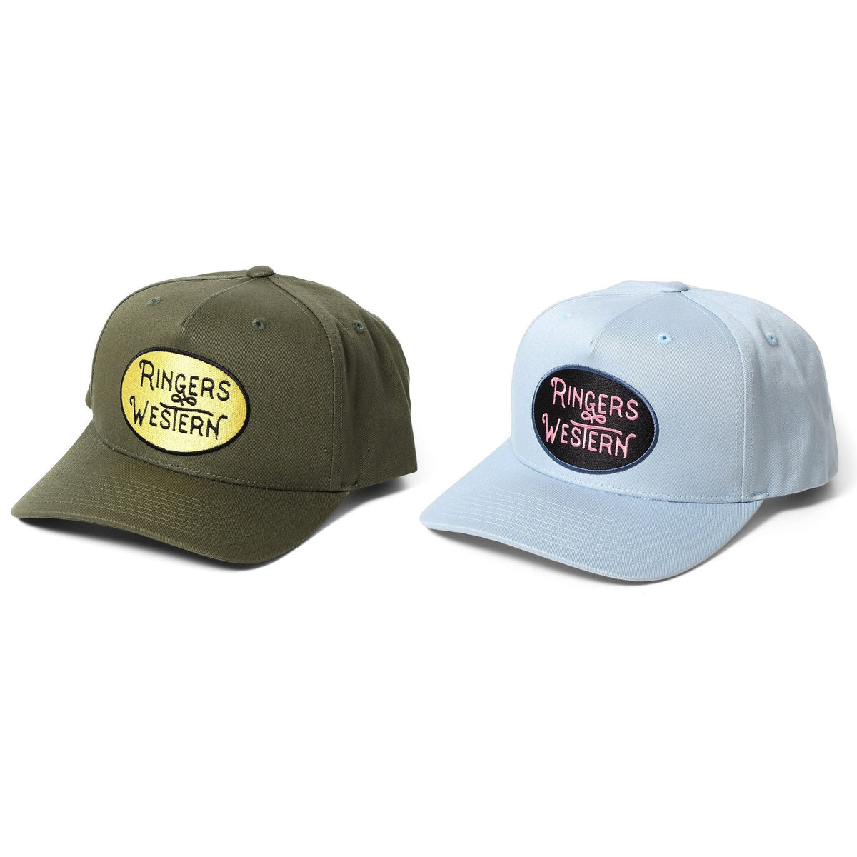 Two Ringers Western Truckstop Baseball Caps are displayed side by side. The cap on the left is olive green with a yellow oval patch featuring the text "Ringers Western." The cap on the right is light blue with a navy blue oval patch featuring the same text. Both caps have curved brims and adjustable straps.