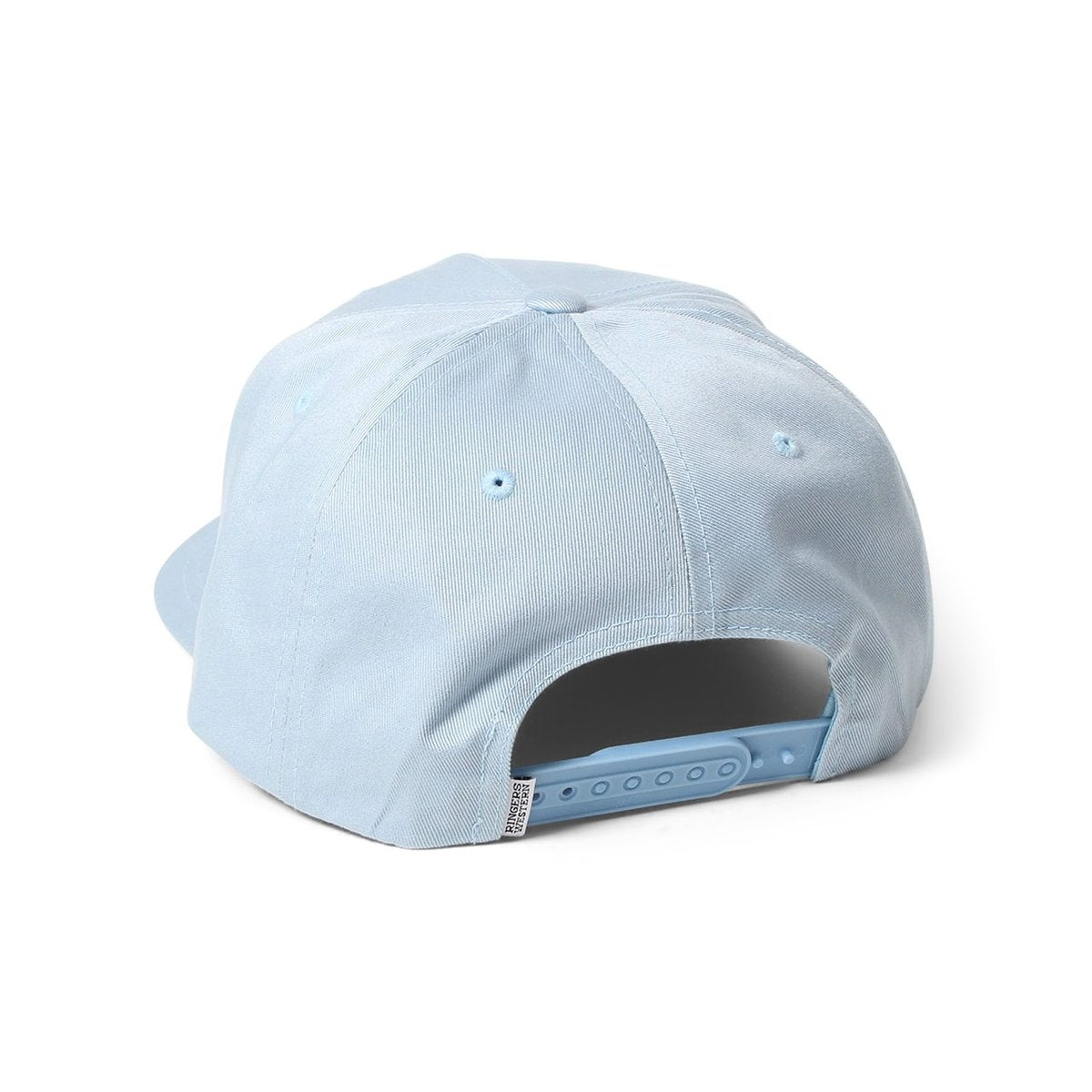 The Ringers Western Truckstop Baseball Cap in light blue is shown from the back, featuring an adjustable strap with multiple holes for resizing, a small Ringers Western tag on the bottom left, and ventilation eyelets on the top. The fabric has a smooth texture, and the brim is partially visible.