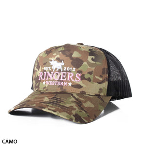 The Ringers Western Western Star Trucker Cap showcases a camouflage design and mesh back, with "EST. 2012 RINGERS WESTERN" embroidered in pink on the front. A small graphic of a horse and rider is positioned above the text, and the cap features an adjustable strap for a perfect fit. It is labeled "CAMO" at the bottom left corner of the image.