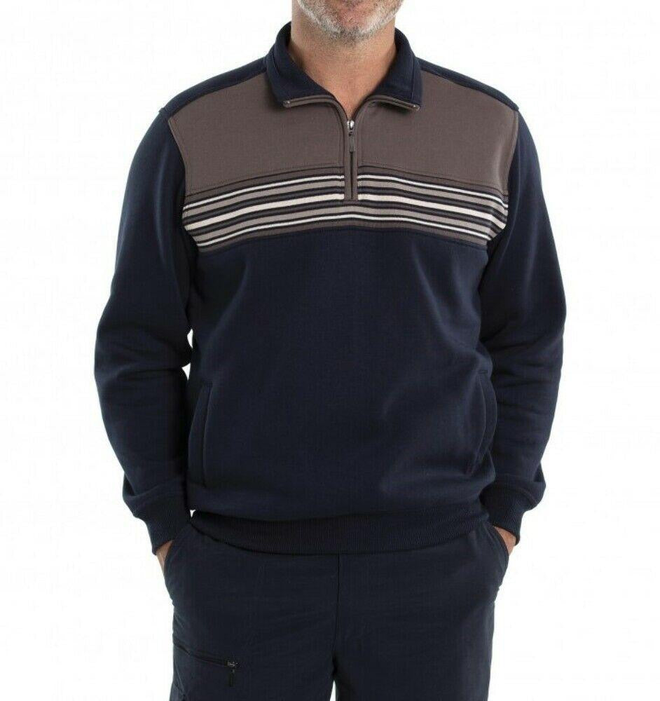A man wearing a navy blue and brown Breakaway Dex Snowy Mt Fleece Half Zip with horizontal stripes stands with his hands in his pockets against a plain white background. His face is not visible in the image, making the cosy fleece winter staple the focal point of this stylish snapshot.
