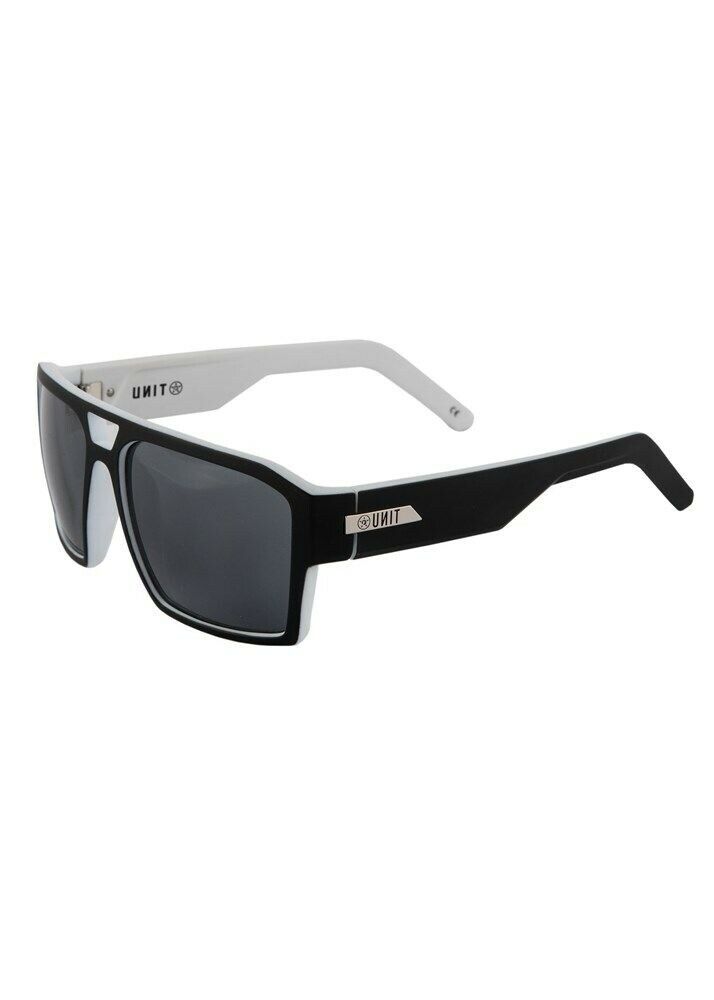 The UNIT Vault Eyewear offers a stylish design with a thick black front frame and contrasting white arms. The lightweight construction ensures comfort, while the dark-tinted lenses provide UV protection. Additionally, there's a small logo on both arms near the hinge.