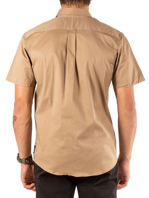 A person is shown from the back against a white background wearing the UNIT Craftman Stretch Short Sleeve Shirt in light brown and black pants.