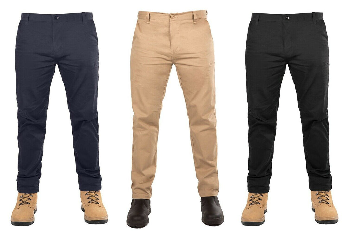 Three pairs of UNIT Ignition Stretch Pant trousers are worn by mannequins sporting boots. The durable work pant comes in three different colors: dark blue on the left, beige in the middle, and black on the right. The boots with the dark blue and black trousers are light brown, while the middle pair has dark brown boots.