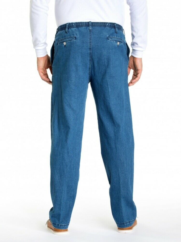 A person is standing with their back to the camera, wearing a white long-sleeve shirt and mid-rise blue Breakaway Ipswich Denim Jeans featuring back pockets with button closures. They are also sporting light-colored shoes against a plain white background.
