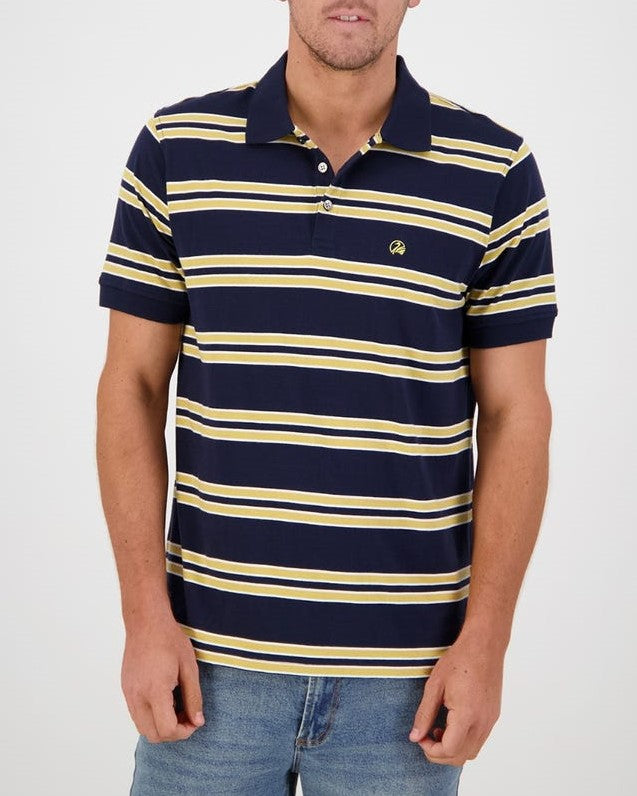 A man wearing a dark blue Swanndri Lincoln Stripe Polo with horizontal yellow and white stripes and blue jeans stands against a plain white background. The casual polo shirt, made from 100% cotton, features a small logo on the left side of the chest.