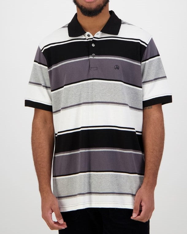 A person is seen against a plain backdrop wearing a Swanndri Kingfield Stripe Polo, which is short-sleeved and made from 100% cotton, in black, gray, and white stripes. The shirt features a collar with buttons at the top. The person's face is not visible.