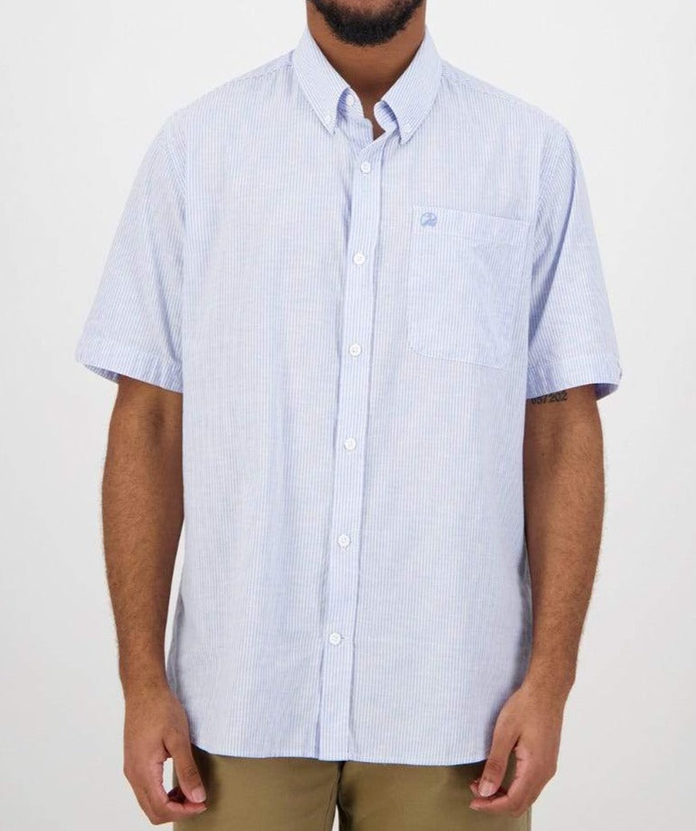 Someone wears the light blue Swanndri Hinsdale Shirt, a comfortable short-sleeve 100% cotton button-up with a subtle striped pattern and a left pocket. They pair it with khaki pants, while their face remains out of view.