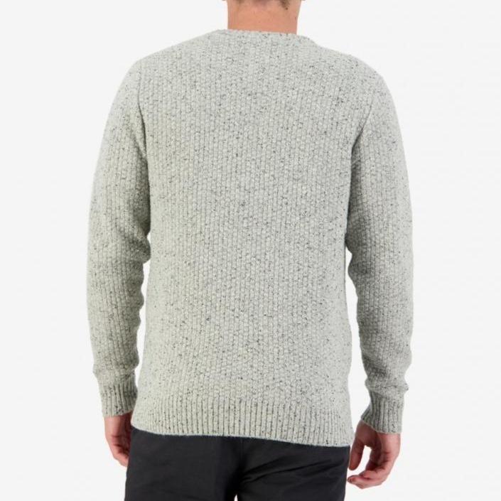 A person is wearing a Swanndri Sentry Hill Knit Crew in light gray lambswool and dark pants, viewed from the back. The sweater features a textured, speckled pattern against a plain white background.