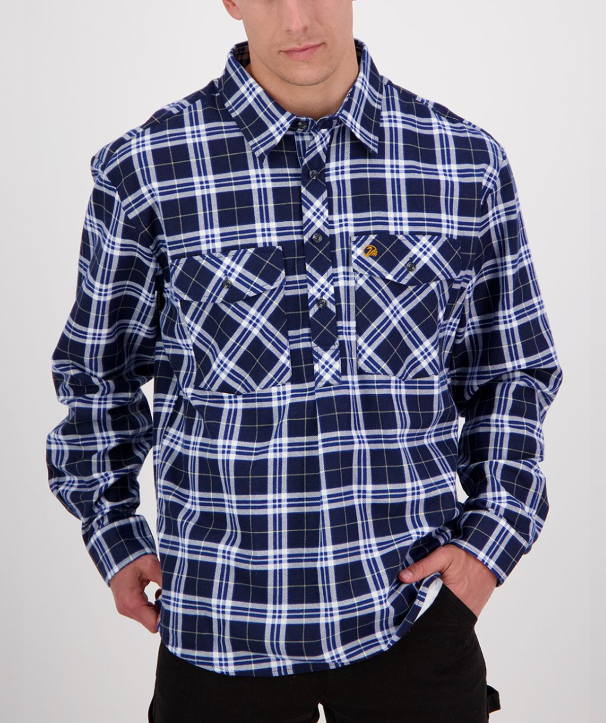 A person wearing a Swanndri Egmont Flannelette plaid shirt in blue and white crafted from brushed cotton poses with hands in pockets. The long sleeve shirt features two front pockets, one with a small embroidered logo.