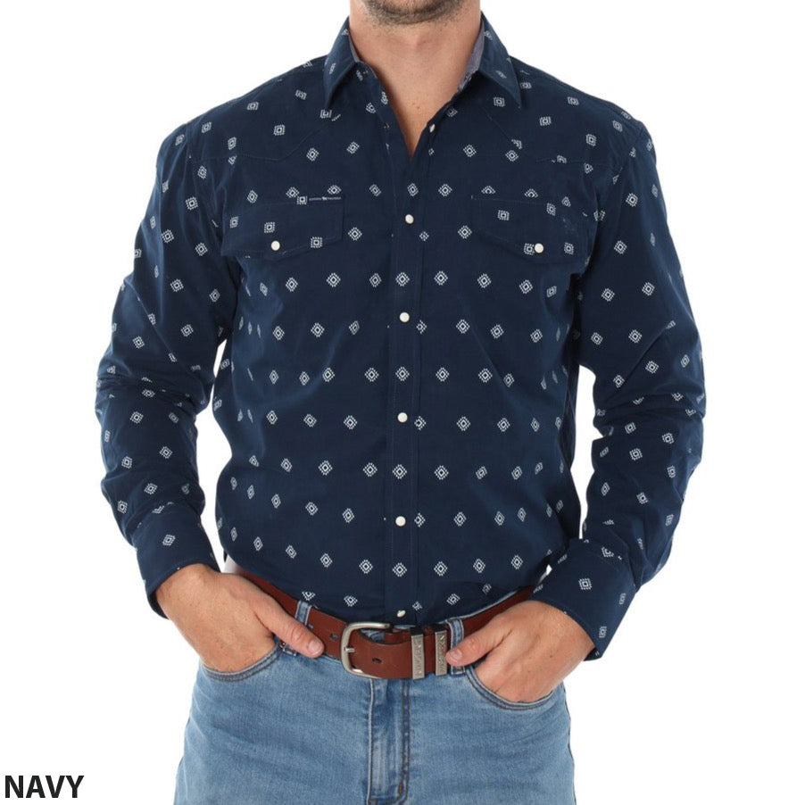 A person is wearing a navy blue, long-sleeved Ringers Western Wyoming Shirt featuring a white geometric pattern and paired with blue jeans. This semi-fitted shirt, made from 100% cotton, includes two chest pockets. The person has their hands in their jean pockets, with "NAVY" written at the bottom left corner of the shirt.